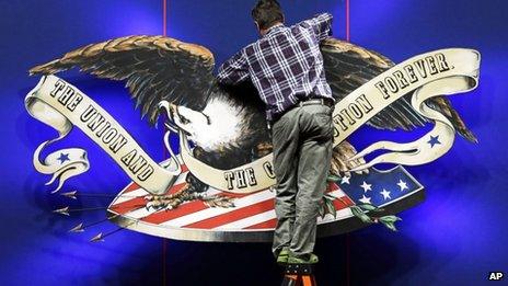 A worker prepares the backdrop for Monday's presidential campaign debate in Boca Raton, Florida, 21 October 2012