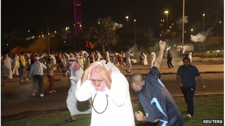 Protesters running from tear gas during a demonstration against proposed changes to election laws in Kuwait