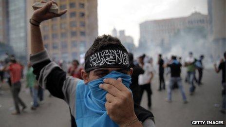 A supporter of the March 14 movement throws stones towards Lebanese security forces