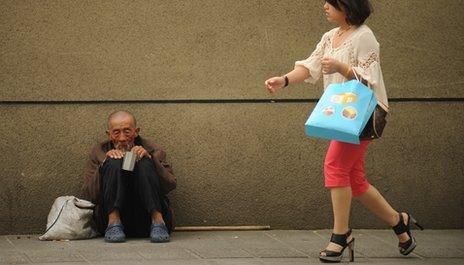 Woman and beggar in Beijing