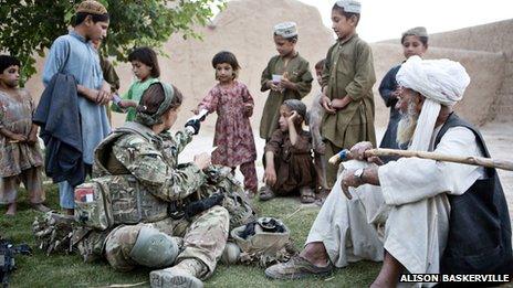 A British female soldier talking to Afghan villagers