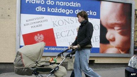 A mother with a child passes a poster with inscription "Right to be born for every child" in Warsaw 15 March 2007