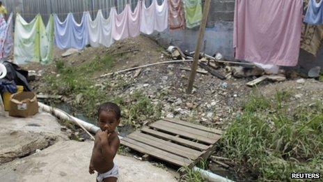 A child stands next to a clothes line in the low income neighbourhood of Curundu in Panama City, 27 September 2012