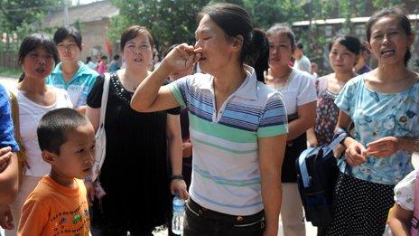 A group of upset Chinese migrant workers gather outside an 'unlicensed' school, after they arrived to register their children for the new semester but were informed that the school will be shutdown, in the suburbs of Beijing on August 10, 2010