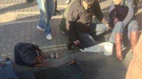 The woman lies injured as smoke emerges from the manhole