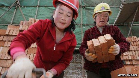 Women migrant workers remove bricks at a construction site on April 5, 2005 in Xining of Qinghai Province, China.