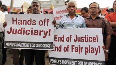 Opposition activists hold up placards during a protest in Colombo