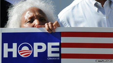 A woman holding an Obama sign saying "hope"