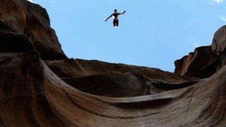 diver jumping off a cliff edge