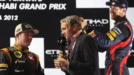 David Coulthard is drenched by Sebastian Vettel while interviewing Kimi Raikkonen (left).