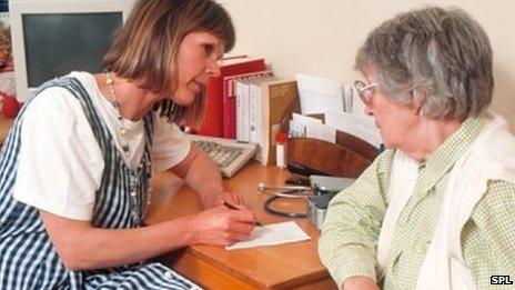 GP taking notes with a patient