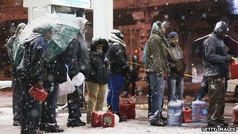 People wait in the snow for petrol in Brooklyn, New York 7 November 2012