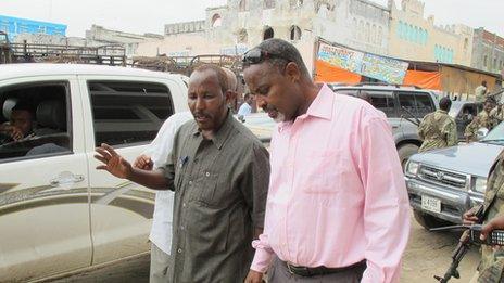 A local businessman speaks to the mayor as he leaves his office