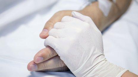 Nurse holding a patient's hand