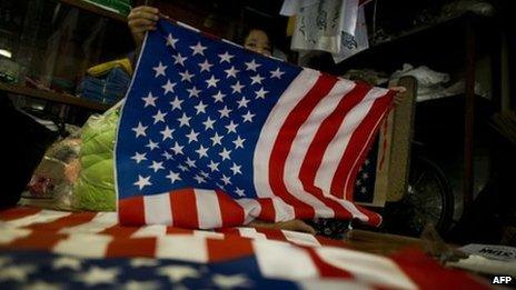A woman folding flags of the US at a shop in Rangoon, 16 November 2012