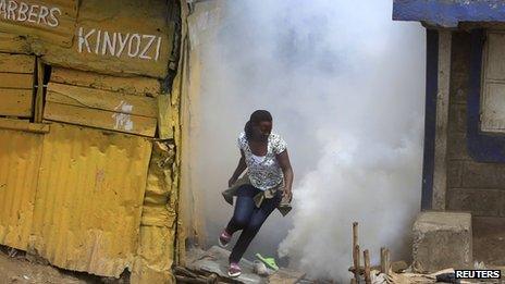 A woman flees from tear gas fired by police in Eastleigh (19 November 2012)