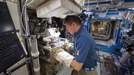 Italian astronaut Paolo Nespoli conducting experiments on the space station