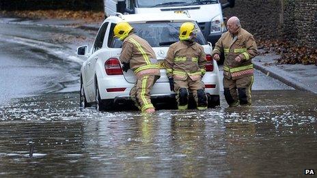 A fire service crew removes a car from floodwater near Tetbury, Gloucestershire