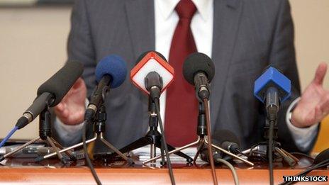 Man in a suit talking at a podium