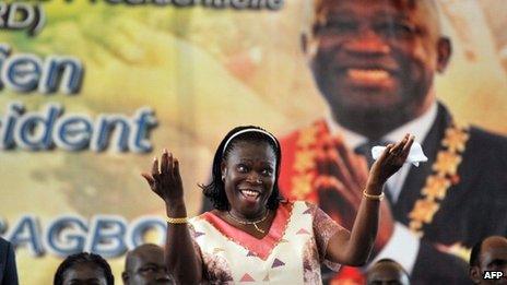 Simone Gbagbo dances under a portrait of her husband, during a meeting in his support on 15 January 2011 in Abidjan