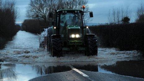 A tractor on a flooded road near Moorland, Somerset