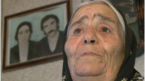 Antiga Gahramanova stands in front of a picture of her dead daughter and son-in-law