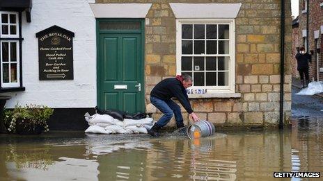 Man scooping water away from property
