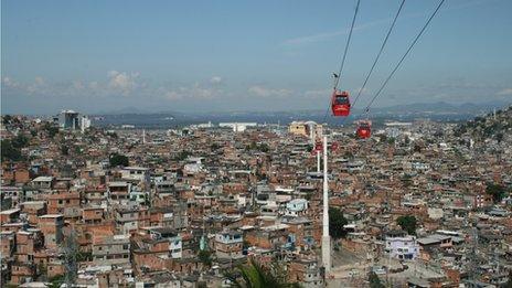 Cable cars travel above the Complexo do Alemao shanty town in Rio de Janeiro