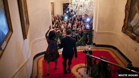 First Lady Michelle Obama and President Barack Obama descend the stairs to a December 2009 White House Christmas celebration