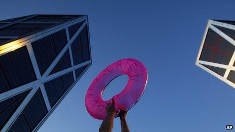 A protester holds a life saver in front of a bank in Madrid. Photo: June 2012