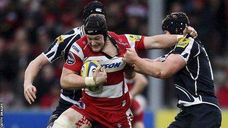 Tom Savage is tackled by two Sale Sharks players