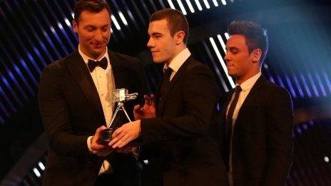 Josef Craig (centre) receives his award from Ian Thorpe and Tom Daley (right)