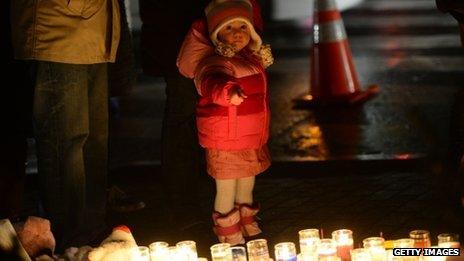 A young child points at candles in Newtown, Connecticut