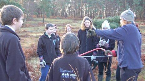 Warden show students how to use saw