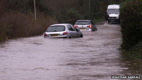 Cars submerged in water on a flooded road in Wallington