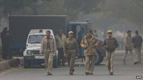 Indian policewomen walk along a sealed-off road leading towards the landmark India Gate monument following weekend clashes between demonstrators and police in New Delhi on December 24, 2012.