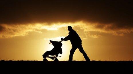 A father pushes a child in a pushchair