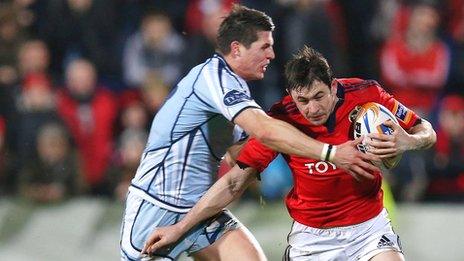 Richard Smith of Cardiff tackles Munster's Felix Jones at Musgrave Park