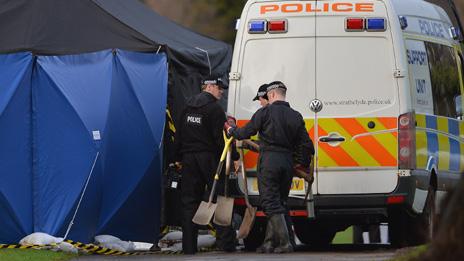 Forensic officers at the grave