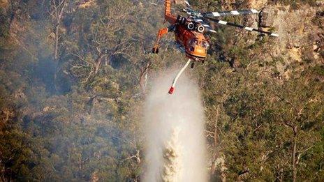 A helicopter dumps water on a fire in New South Wales. Photo: 11 January 2013