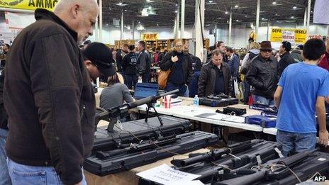 Gun show goers look at various assault-style weapons December 30, 2012 at the Nation"s Gun Show in Chantilly, Virginia