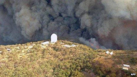 Aerial picture provided by Rural Fire Service (RFS) of New South Wales shows smoke billowing from an out-of-control fire raging towards the Siding Spring Observatory on 13 January 2013