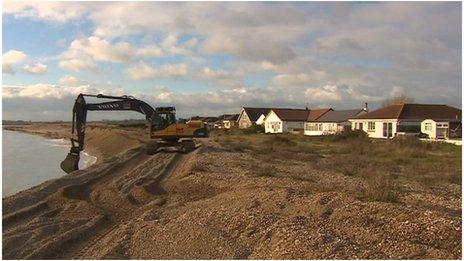 Digger adding gravel to beach at Pagham