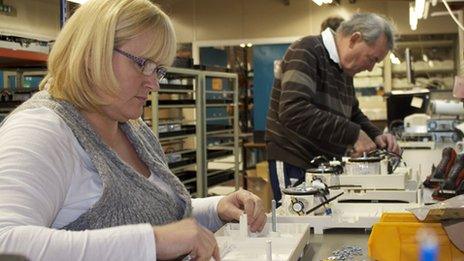 Staff work a small assembly line