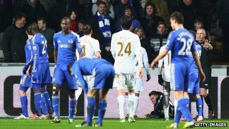 Ball boy Charlie Morgan lies on the ground at the Liberty Stadium after his clash with Eden Hazard