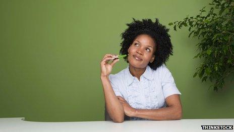 Woman sitting at her desk thinking