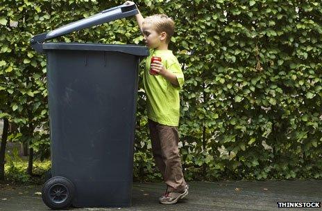 Boy putting a can in a bin