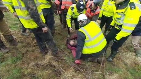 Bailiffs and an activist at the Bexhill to Hastings road site