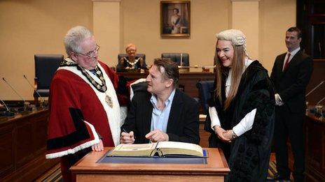 Liam Neeson signs the book of burgesses