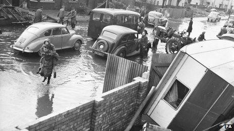 A woman carried along a flooded street in the Wisbech Road area in King"s Lynn